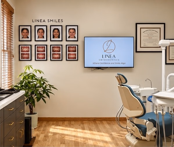 Treatment room with the Linea Smiles photo wall and a branded screen