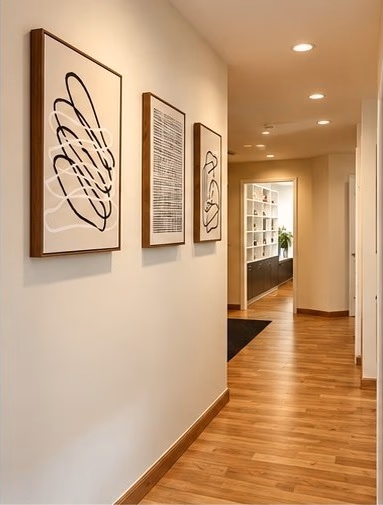 Hallway with framed line art leading into the office